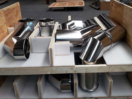 An array of stainless steel duct parts shown in a stock warehouse.