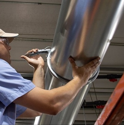 Technician installing Nordab Ducting for cardboard dust removal.