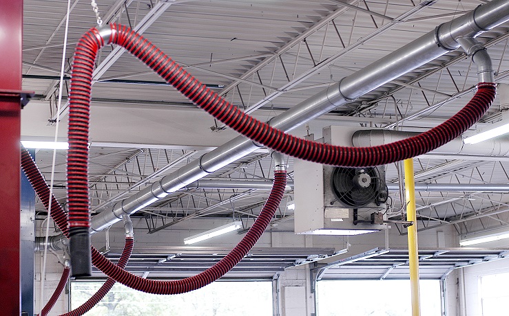 Vehicle exhaust removal ducting shown in car dealership to effectively remove exhaust.