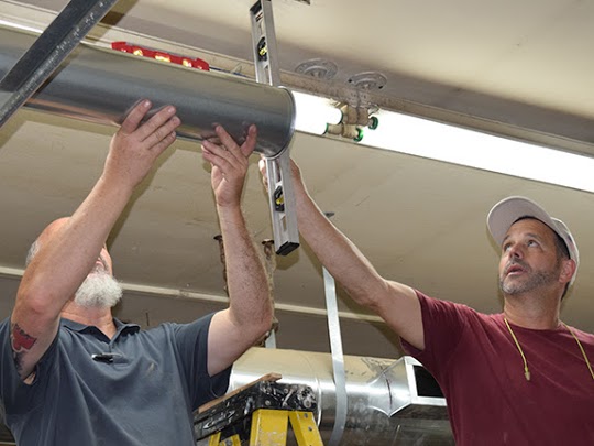 Nordfab ducting being installed by two workers.