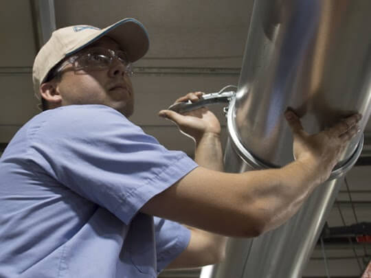 Technician installing Nordfab Quick-Fit, clamp-together ducting.